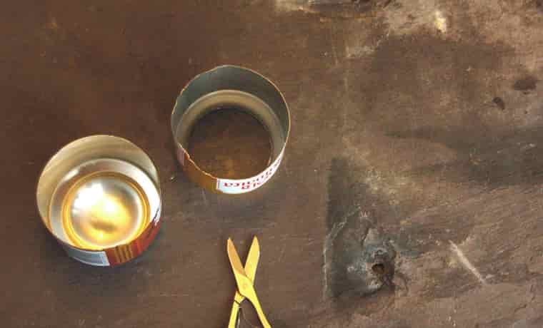 Two soda can halves with scissors