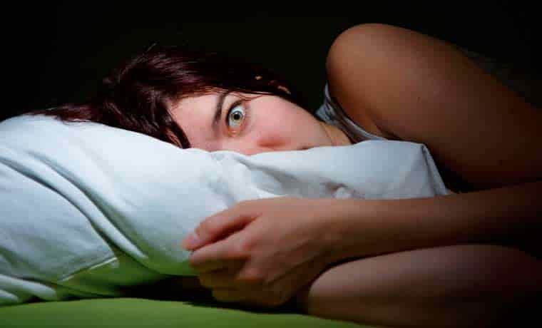 Woman scared in bed at night
