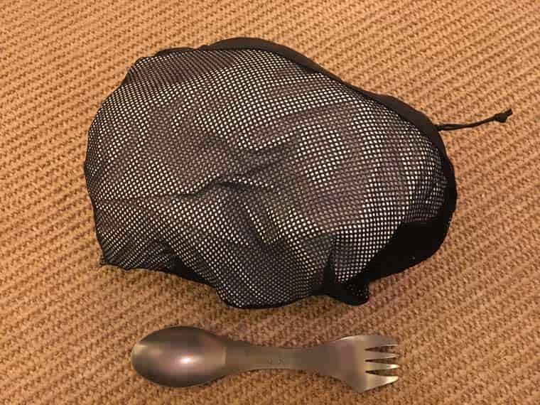 Packed waterproof pants next to spoon