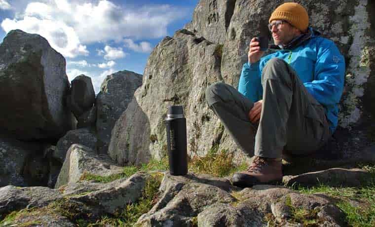 Man drinking on rocks