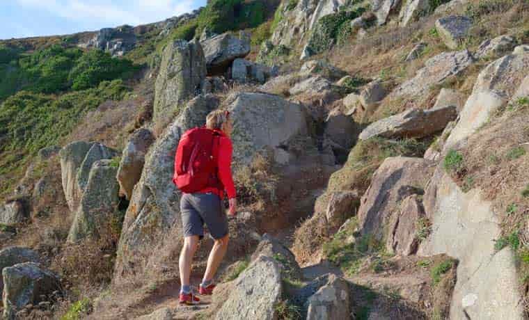 Woman hiking up steep trail