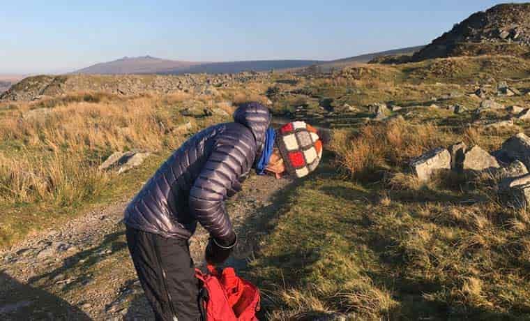 Woman packing bag in hills