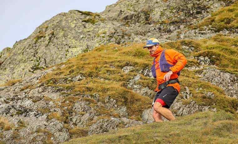 attributed Man running on trail in orange jacket