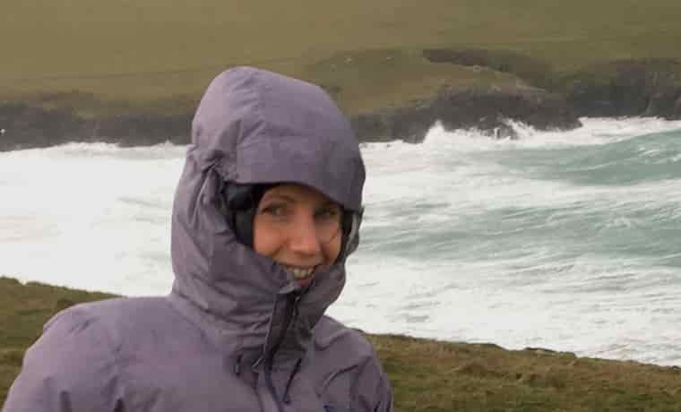 Woman by the sea with hood up