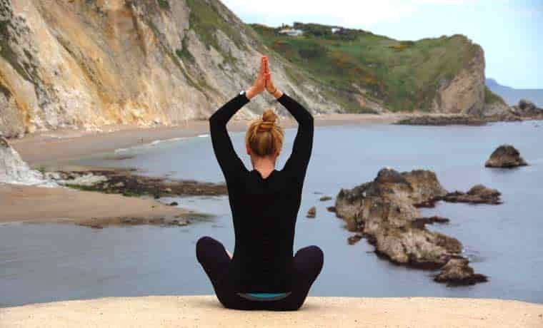 Woman doing yoga by the sea