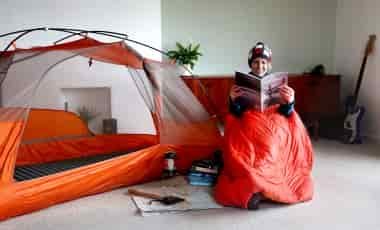 Woman reading next to tent in lounge