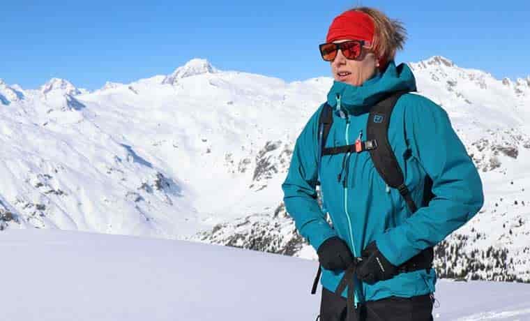 Woman doing up backpack in mountains