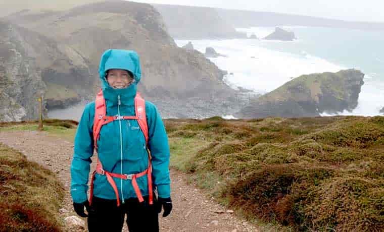 Woman in rain jacket on coast path