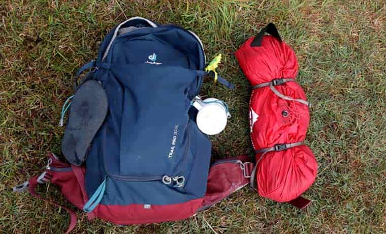 Packed tent next to bag