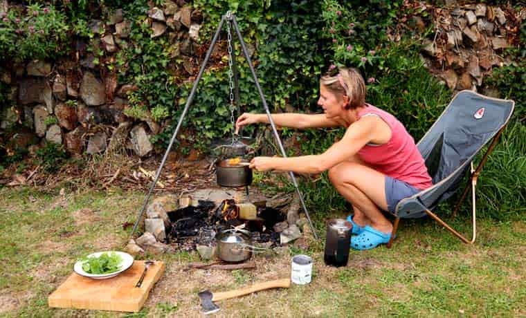 Woman cooking over campfire