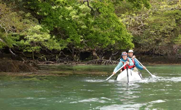 Couple paddling a folding canoe