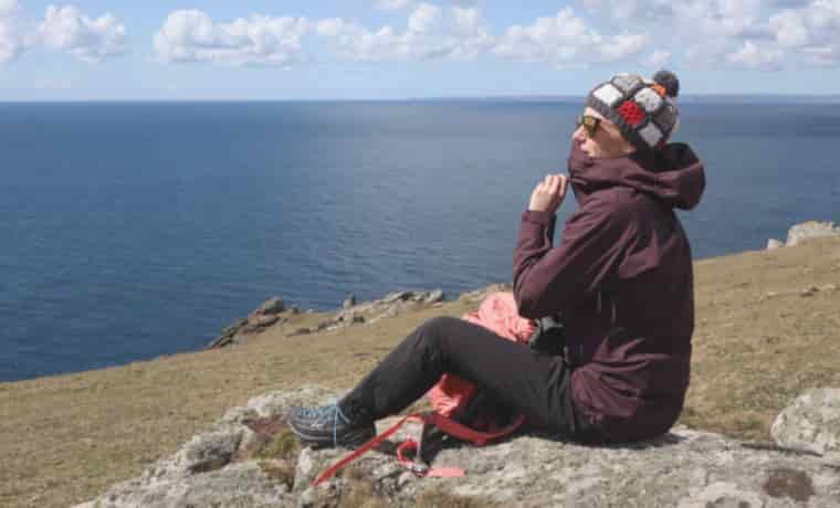 Woman sitting on rock by the sea