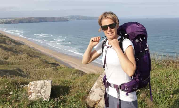 Woman adjusting backpack by the sea