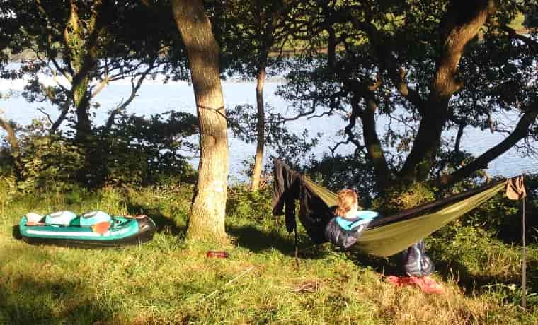 Woman in hammock with canoe