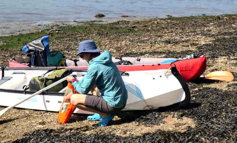 Woman packing up canoe for camping