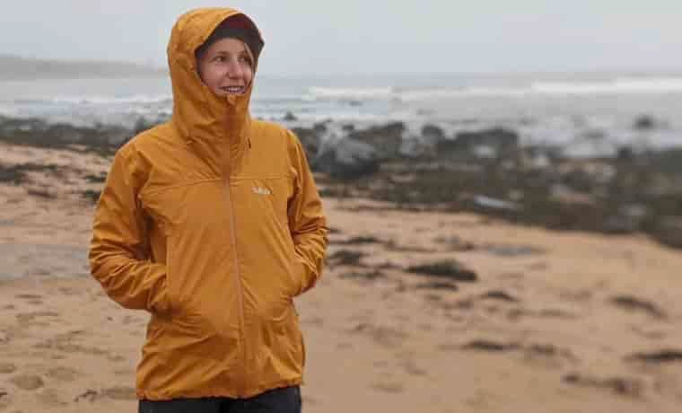 Woman standing on the beach with hood up
