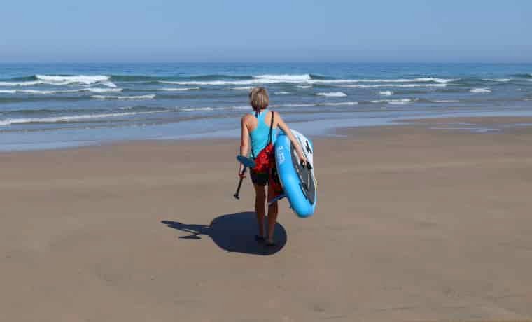 Woman walking with paddle board