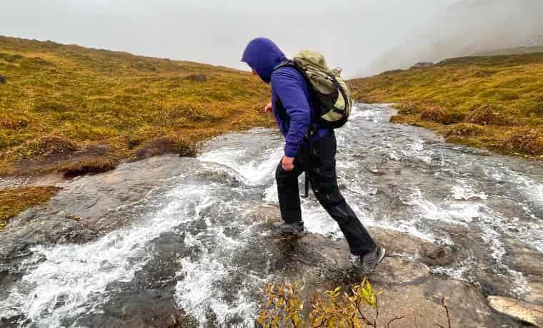 Ellie crossing river in Lowa hiking boots
