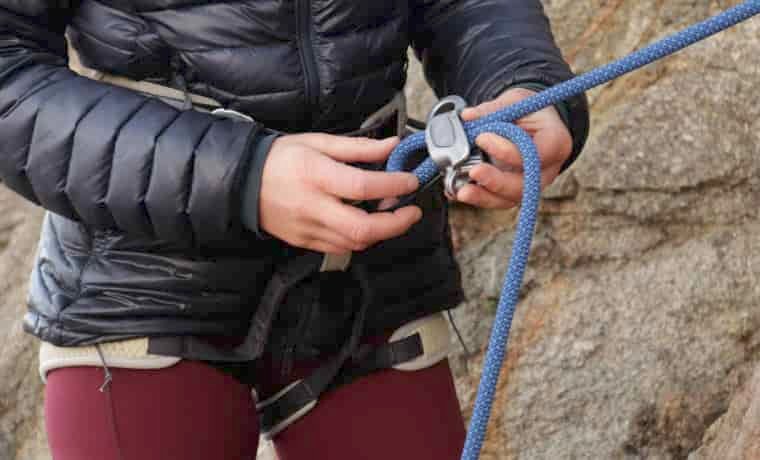 Person feeding rope into ATC belay device