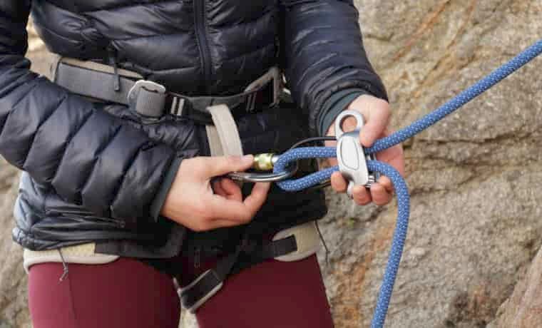 Person feeding rope into ATC belay device