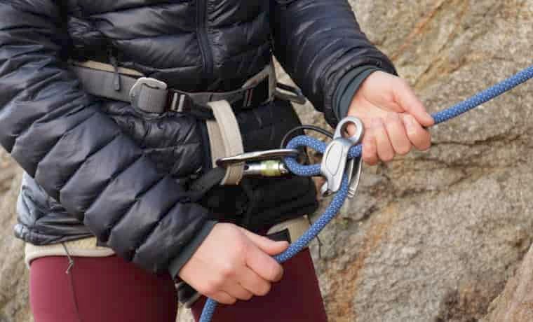 Person feeding rope into ATC belay device