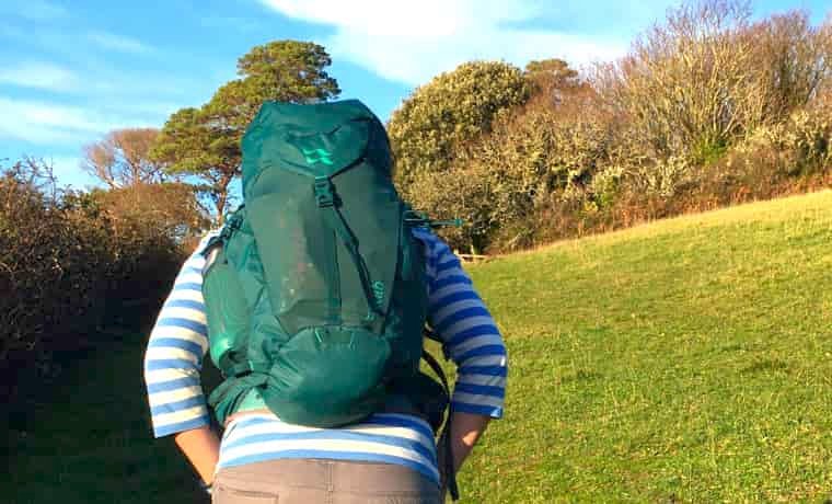 Woman hiking with green Rab daypack