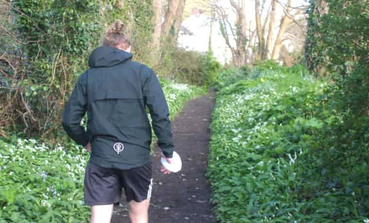 Man running in the woods in black jacket