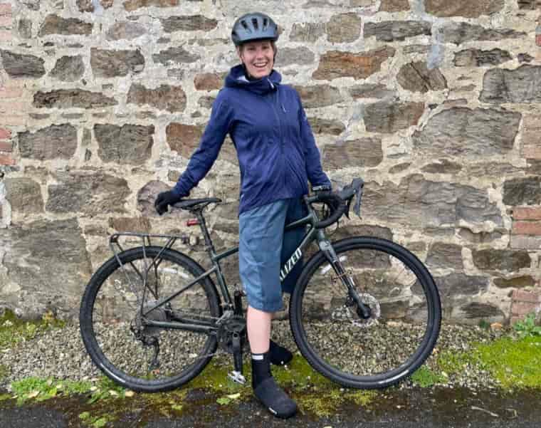 Woman standing with bike in the rain