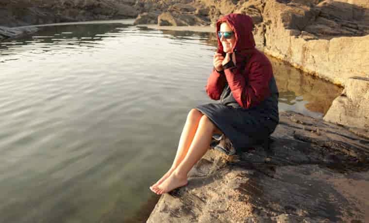 Woman sitting by rock pool
