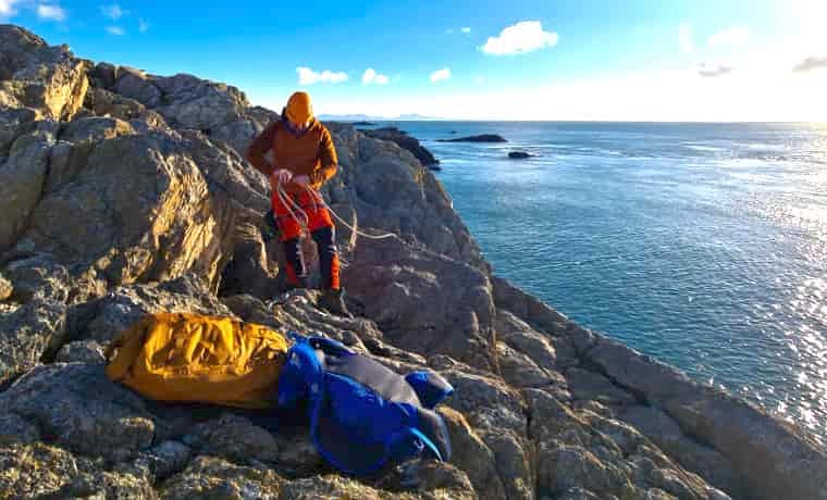 Climber sorting ropes by the sea
