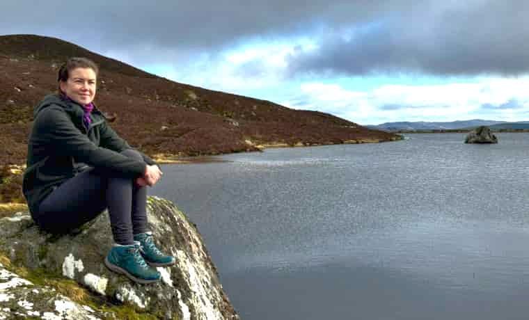Woman hiker sitting by the sea