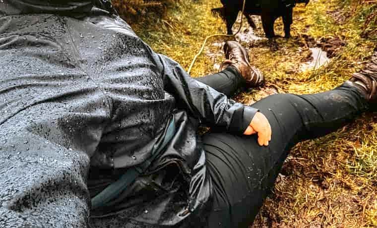 Woman sat in the mud and rain
