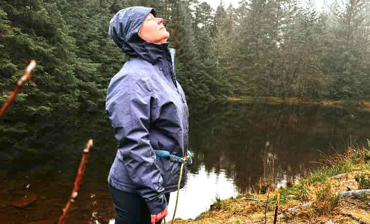 Woman wearing jacket by lake