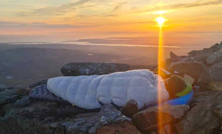 Man bivvying at sunset