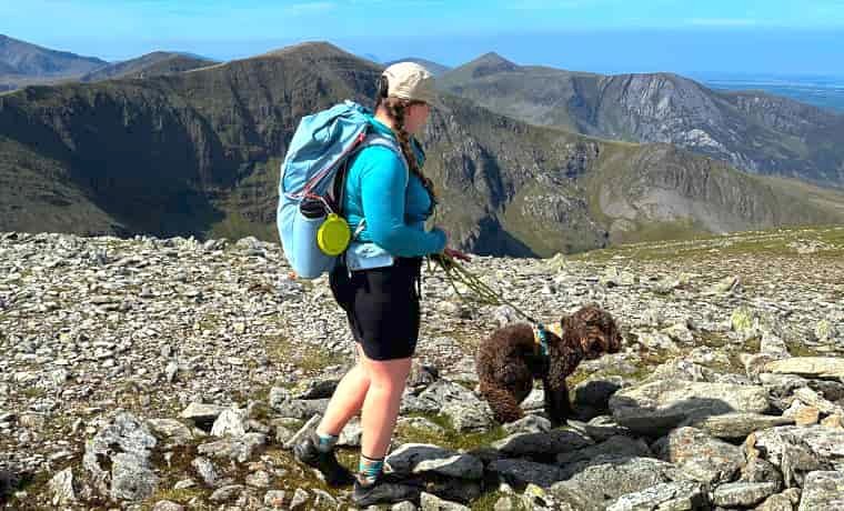 Woman hiking in mountains with dog