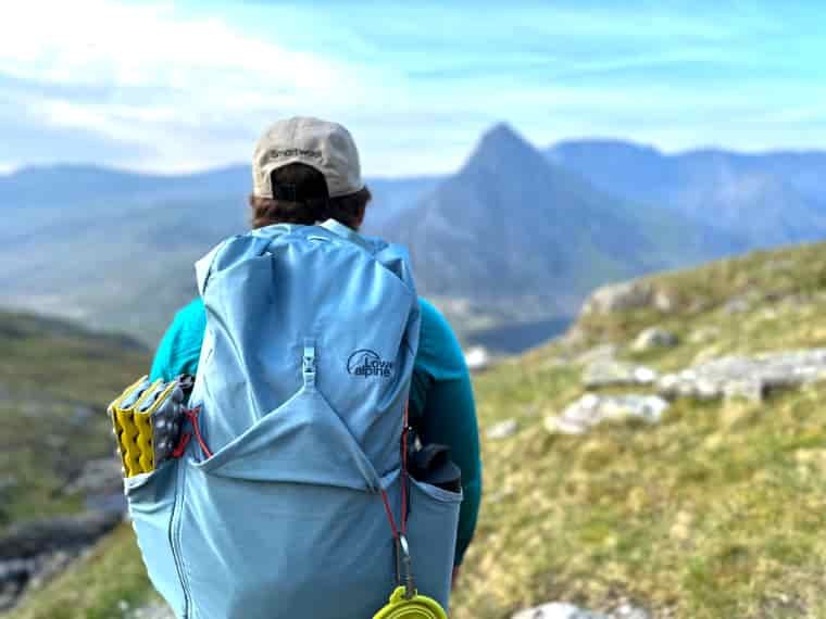 Woman in mountains carrying backpack