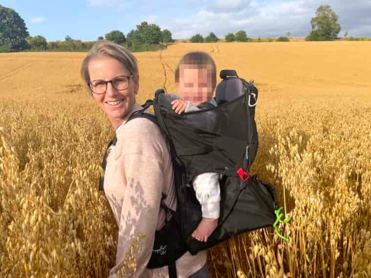 Woman carrying child in field