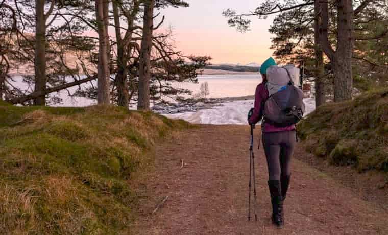 Woman hiking at sunset with backpack